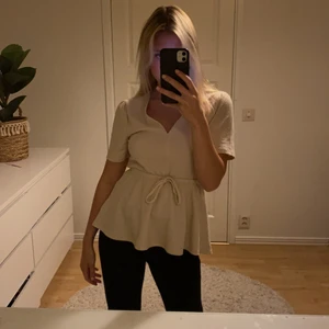 Beige blus - Söt blus/tröja med dett band i mitten med rosett. Aldrig använd.