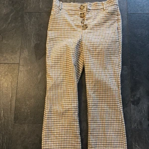 Rutiga kostymbyxor Zara - Så snygga rutiga mjuka kostymbyxor från Zara. Schyssta knappar och lätt utsvängda nertill. Strl 36