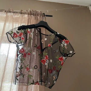 Meshtopp med mönster - Snygg meshtopp med blommor som mönster. Perfekt som festtopp.