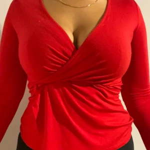 Röd urringad tröja  - Supersnygg röd urringad tröja, super strechig och bekväm. Storleken är S men passar M