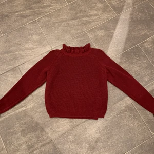 Vinröd tröja  - Superskönt vinröd tröja med volang vid kragen och vid armen 