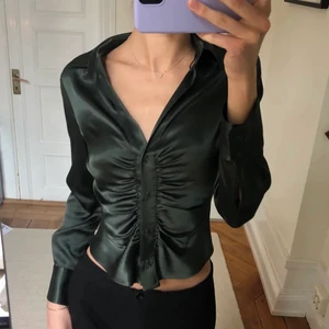 Grön skjorta i satin  - Super fin skjorta från Zara som är i en figur sydd form. Första bilden är lånad då den inte sitter så bra på mig längre. Jätte fin till fest. Storlek S. Köparen står för frakt