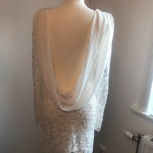 Fest/ student eller brudklänning stl 36 - Aldrig använd bara provad, underbar klänning från Nelly eve, lågt urringad rygg med svepande vit skir chiffong tillsammans med exklusiv vit skimrade spets 💕