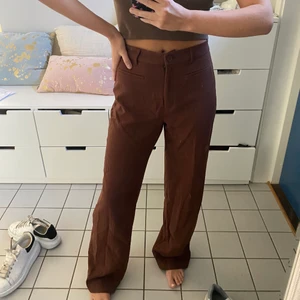 Bruna kostymbyxor - Ett par bruna kostymbyxor från Monki i storlek 38☺️ Sitter väldigt fint på men är tyvärr för stora för mig. Köpt för 350-400kr i vintras☺️