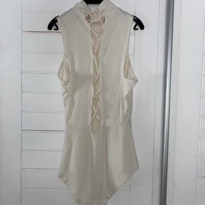 Vit body - En super fin vid body med knytning i ryggen. Bodyn är ett linne, det har även en jätte fin knytning bak i ryggen (se dom två första bilderna). Materialet är jätte mjukt och den sitter superfint på. Det är en tajt modell vilket gör att ens former synd tydligen vilket jag själv tycker är super fint. Även på denna tröja har min syster dock skrivit (C.T) men inte häller här är det något man tänker på eller ser tydligt. 