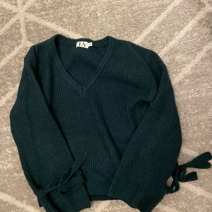 Stickad tröja med knytning vid armarna  - Stickad tröja i färgen grön, med knytning långt nere vid armarna. Strl Xxs, stor i storleken så passar xs-s. Från Linn ahlborgs tidigare kollektion
