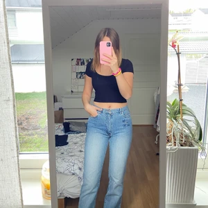 Lågmidjade jeans med broderad blomma  - Raka lågmidjade jeans med broderad blomma på sidan fram och på fickan bak. Använda men i fint skick! 