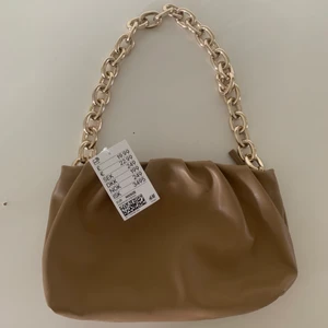 Väska - En jättefin beige handväska med guldigt kedjeband. Köpt för hm för 250 o aldrig använd, lappen kvar. Säljs inte längre. 💖💖