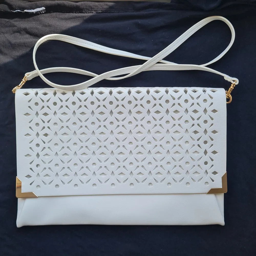 White openwork clutch with a detachable strap and a zipper. Dimensions 30x20 cm.. Väskor.