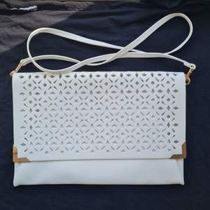 White openwork clutch with a detachable strap and a zipper. Dimensions 30x20 cm.