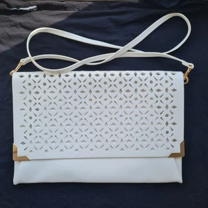 White openwork clutch - White openwork clutch with a detachable strap and a zipper. Dimensions 30x20 cm.