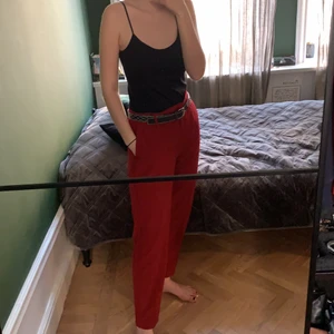 Röda Byxor - Ett par röda byxor i lätt stretchigt tyg. Rem längs med utsidan av benen. Resår i midjan. Säljer pga att de inte längre passar mig. Kan mötas upp i Vasastan eller postas, köpare betalar för post avgifter.