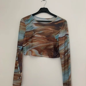 Cool topp - Trendig topp i blå/brun. Jättesnygg till våren! Strl L men skulle säga att det är en M. 