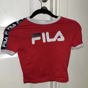 Fila t-shirt - En röd t-shirt som är som en magtröja. Perfekt med ett par lågmidjade eller högmidjade jeans. 