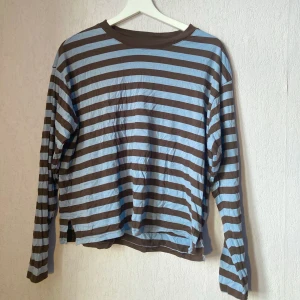 Randig tröja Monki - Randig blå/brun tröja från Monki. Använd en gång, så plagget är i mycket gott skick. Skönt och bekvämt material, även passform.  Paketpris med den andra randiga tröjan från Monki (rosa/röd) = 235