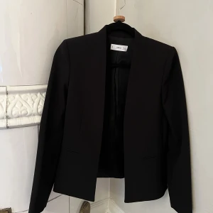 Mango svart kavaj utan slag  - Svart kort kavaj utan slag från Mango. Strl 34. Som ny, väldigt gott skick. 