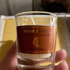 *NY*Litet ljus, Suede Vanilla, Fr Rituals -  Detta exklusiva doftljus från Private Collection har en varm doft av vanilj. Suede Vanilla-doftljuset har en varm och sensuell arom som öppnar med söta och lugnande noter av vanilj och övergår i basnoter av kardemumma, rosmarin, patchouli och vetiveria.