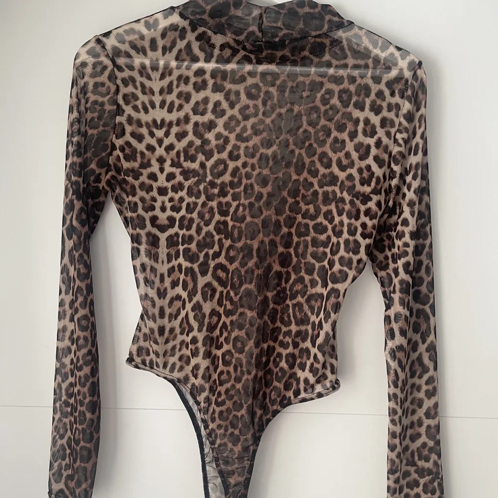 En genomskinlig leopard färgad body från Boohoo. Strl L men är lite mindre i storleken så skulle rekommendera till en M. Använd 2 ggr väldigt fint skick. Köparen står för frakt❤️. Toppar.
