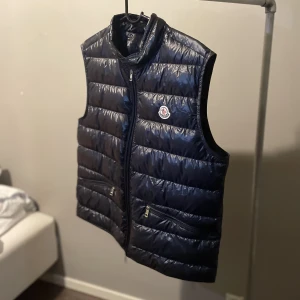 Moncler väst - Moncler Khaki Gui Gilet väst , Mörkblå, Storlek 4/L. Köpt för 3995kr på Vestiaire Collective. Skick 9/10. Säljer för 2999kr.