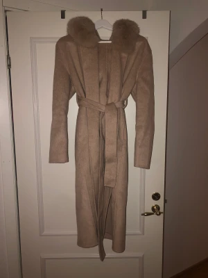 Oanvänd kappa med rävpäls, BUDA - Säljer denna oanvända pälskappa då den är alldeles för stor för mig. Köpte den för 2600kr, och det billigaste jag hittat de online för var 2200kr. Lägg inga skambud tack❤️ Äkta päls, och längden på kappan är cirka 115cm lång  Storleken motsvarar typ S-M 