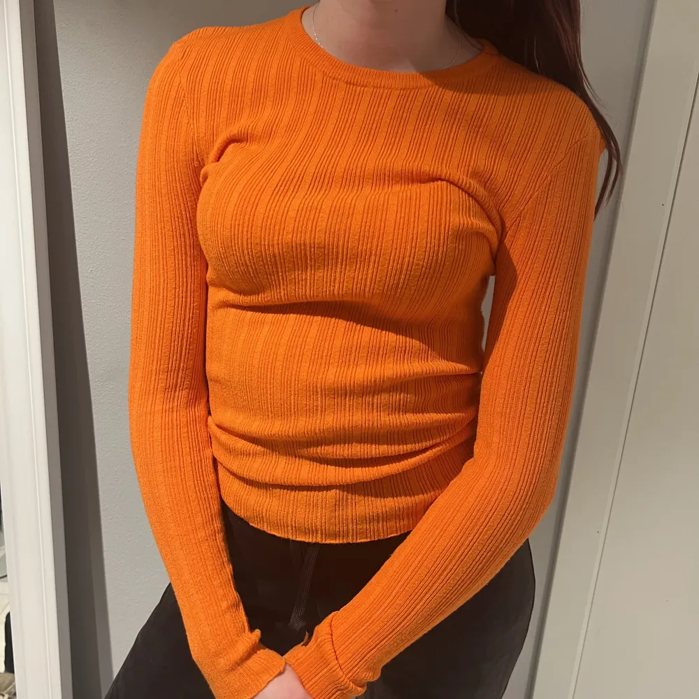 Orange långärmad tröja som är ganska tunn och passar väldigt bra till ett par svarta byxor. Tröjor & Koftor.