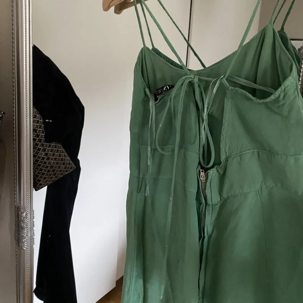 Grön kläning från zara med en slits, man knyter klänningen i ryggen och den har även en dragkedja bak🥰. Klänningar.