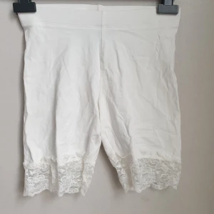 Oanvända Cykelbyxor/korta leggings med spetskant - Ett par cykelbyxor eller korta leggings. Storlek XS från Gina Tricot. Oanvända. Fin spetskant