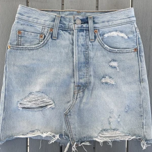 Levis kjol - Jeanskjol från Levis i storlek 24. Kjolen stängs med knappar. Midjemått: 33 cm tvärs över Längd: ca 40 cm