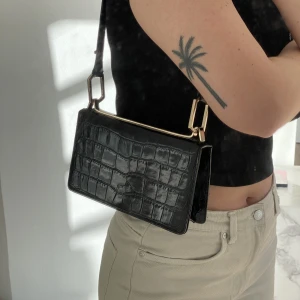 Väska i läder - Liten axelväska i äkta läder med guldiga detaljer. Justerbart axelband. Från & other stories. I bra skick! Köptes för över 1000kr, säljes för 300kr.