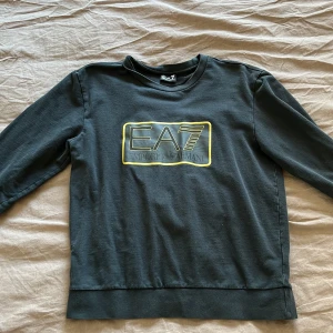 EA7 Emporio Armani Sweatshirt - Hej jag säljer en en fin Armani sweatshirt pågrund av att jag har vuxit ur den. Är använd men i bra skick