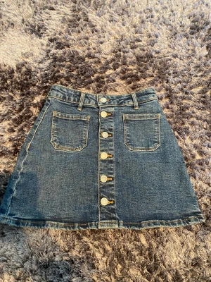 Jeans kjol - En super fin jeans kjol med knappar hela vägen. Inga defekter och helt hela och är i nyskick.