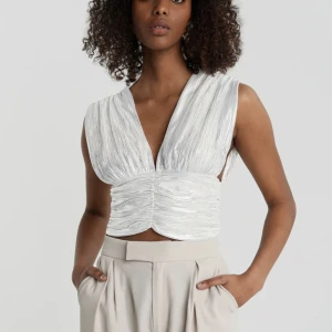 Glittrigt linne - Silver och vit glittrigt linne från Gina Tricot i storlek M. 🌻 Linnet har öppen rygg och knytband i ryggen. Använd endast ett fåtal gånger 🌻