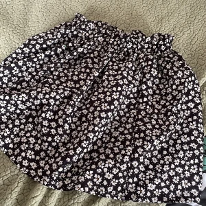 Svart kjol - Svart kjol med vita blommor. Köpt för 159 kr totalt me frakt från shein.  säljer för 50, använd fåtal gånger. Pris kan diskuteras 