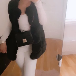 Storlek 36/38 - FAKE FUR  VEST  70cm lång, svart, köpt på garouff för 899kr. Använd få antal gånger pga ändrat stil❣️ En av fickorna va trasig men har syt ihop det nu det syns ej!