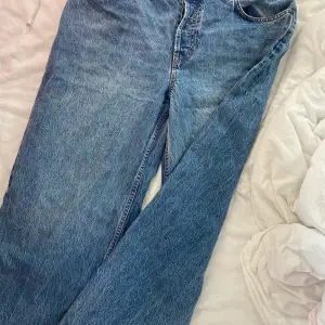 Blå Baggy lågmidjade  jeans från asos  litten fläck på benet fram 