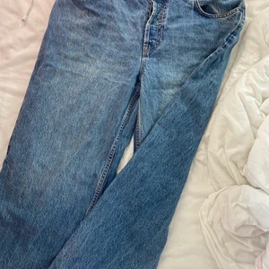 Lågmidjade jeans  asos strl 30/32 - Blå Baggy lågmidjade  jeans från asos  litten fläck på benet fram 