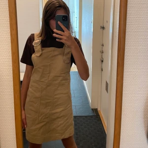 Hängselklänning  - Hängselklänning i beiget 
