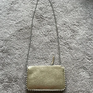 Guldig väska från zara - Säljer denna jättefina väskan från zara då den aldrig har kommit till användning, den är alltså i nyskick. Köpt för 199kr säljer för ännu billigare. Finns ej i butik