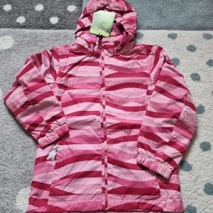 Color kids skaljacka strl.116 - Jacka från Color Kids som är vindtät och vattenavvisande. Jackan har tejpade sömmar, membran samt bra andningsförmåga, Air-flo 8.000.Den är justerbar nedtill och har YKK-dragkedja med hakskydd, avtagbar huva, reflexdetaljer samt fickor med dragkedjor.