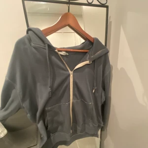 Mörkgrå huvtröja - Enkel huvtröja is mörk grått.