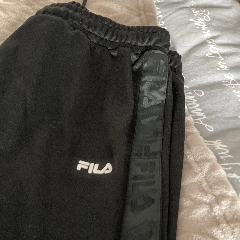 Svarta fila byxor med slits i benen . Farkut & Housut.