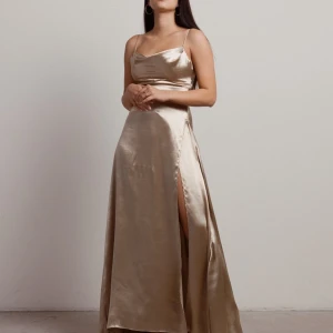 Satinklänning - Säljer min balklänning som endast användes på middagen (inte på festen). Jättebra skick, nästan som ny. Maxiklänning i satin-material, champagne färgad. Skriv om ni vill ha bilder hur den sitter på mig💗  (nypris - 1400kr)