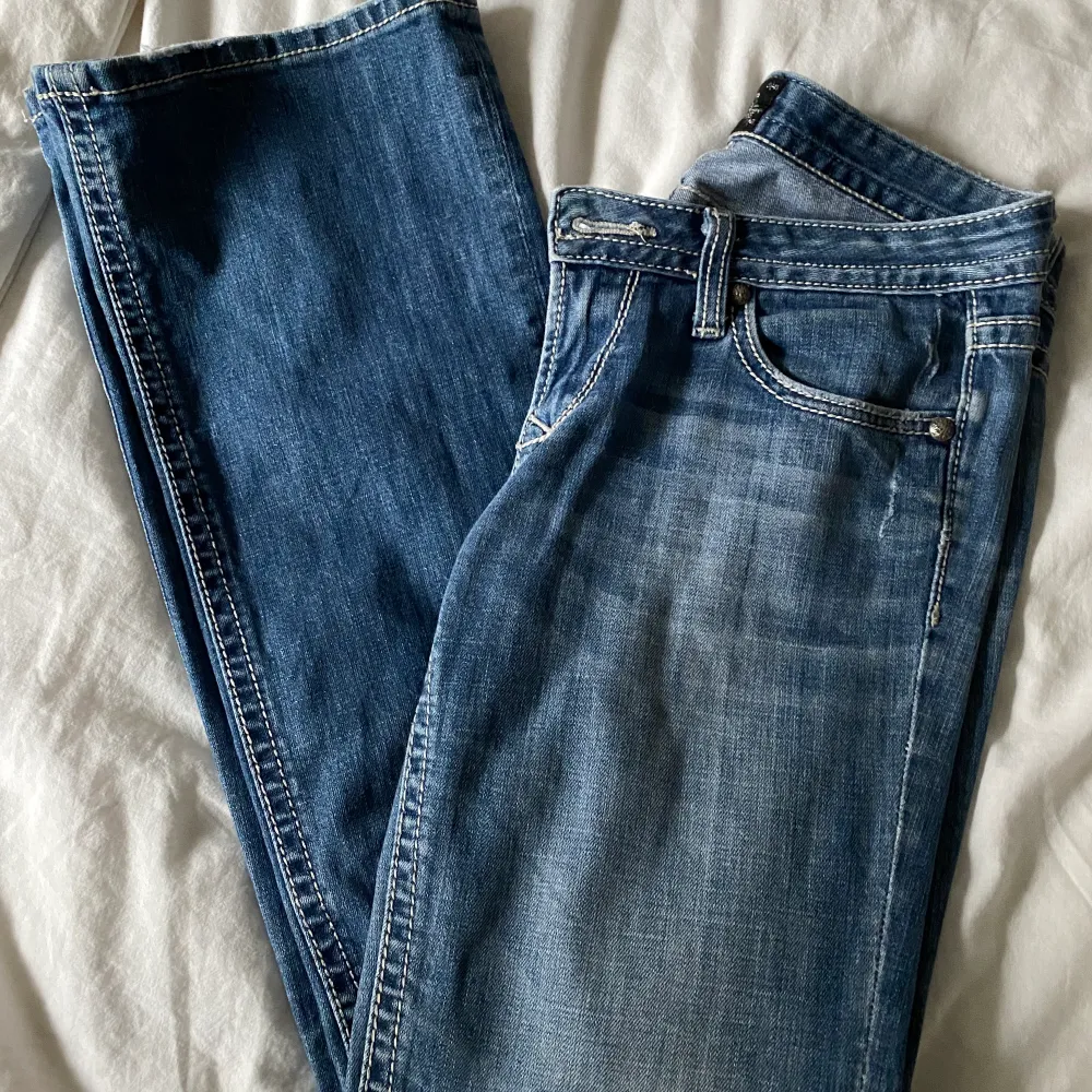 Ett par as feta bootcut jeans mer väldigt låg midja. De har vita sömmar och sitter som en smäck🤌🏼 midjemått ca 84 och innerbenslängd ca 81. De är lite slitna nedtill men inga med hål eller liknande. Vid frågor, kontakta mig. Köpta för 600, använda sparsamt. Jeans & Byxor.