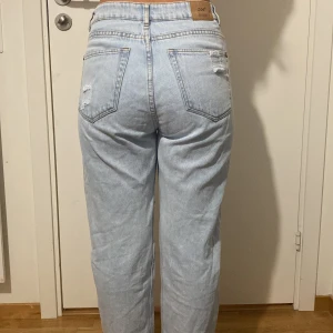 Ljusblåa raka jeans - Ett par ljusblåa håliga jeans som är köpta utomlands i en butik som heter Zoe. Sitter superbra och är jättebekväma. Mycket bra skick, knappt använda. Storlek står inte men skulle säga xs/S