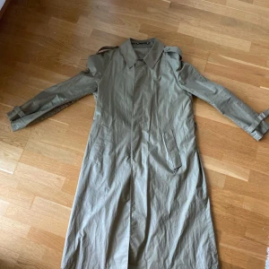 Trenchcoat - Vintage vatten och vindavisande kappa.   Storlek M sitter som M  Pris 99kr  Modellen är 179cm och väger 84kg, har vanligtvis på sig M i tröjor och 33 i byxor
