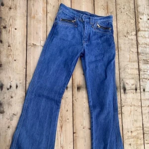 70-tal Jeans Vida Silverdollar Vintage - Sjukt snygga Silverdollar jeans!  Strl 164 Totallängd: 105 cm Innerbenslängd: 83.5 Midja, omkrets:  ca 71 cm Stuss, rakt över: ca  Typ helt oanvända, med en konstig ”defekt” det finns inget hål för knappen… det kan man ju sy själv