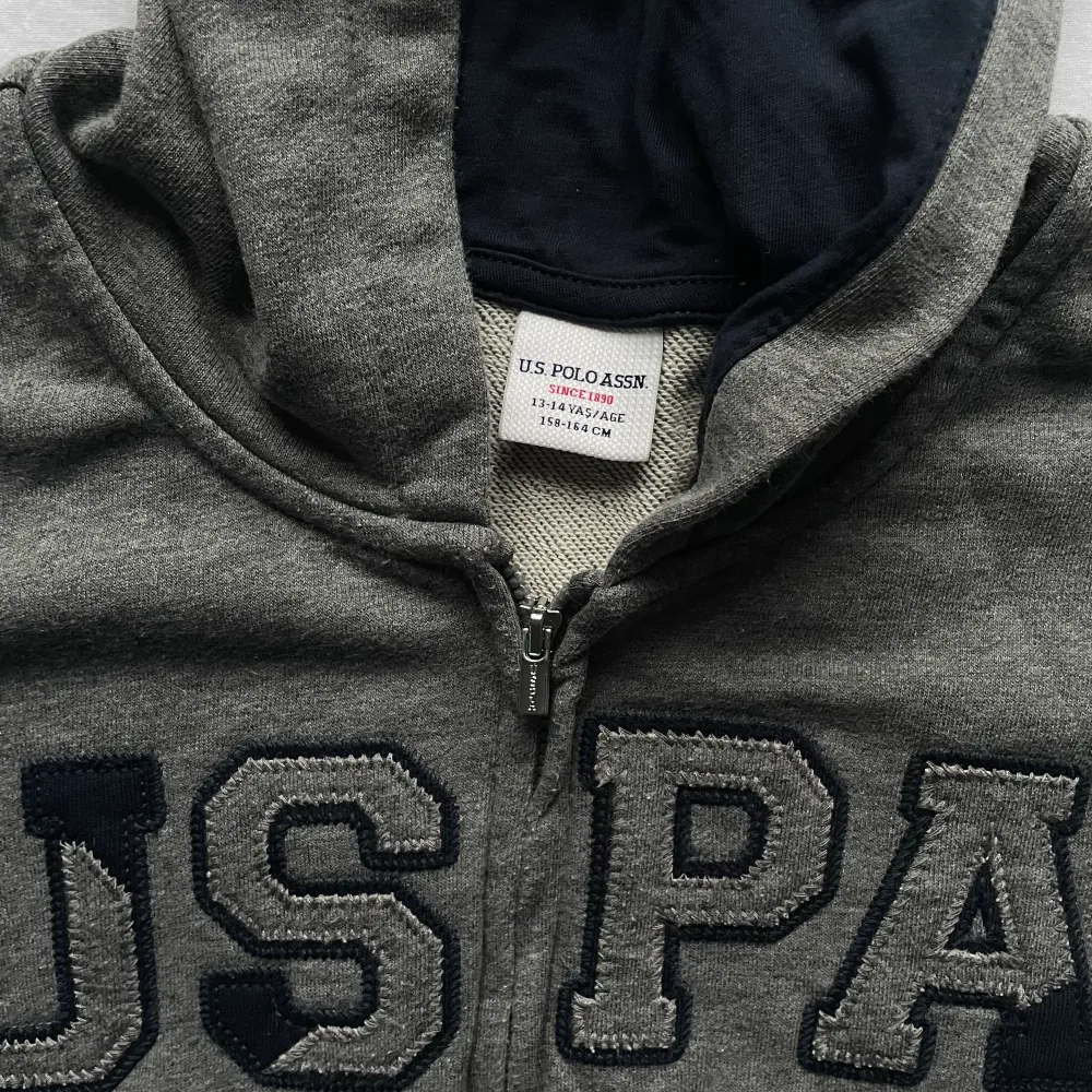 Grå USPA zip up tröja i bra skick finns inga tydliga tecken på användning. Storlek M/S. Hoodies.