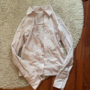 Skjorta - Fin ljusrosa skjorta med grå ränder! Bra skick, dock är lappen lite trasig men inget som syns