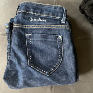 Low waisted Jeans - Super snygga jeans ifrån guess som har lite detaljer på bakfickorna och text. Bra i längd på mig som är 172. De är low waisted och har en cool knapp där man knäpper byxorna.  Tveka inte att höra av er om frågor.