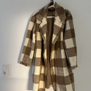 Lång kappa  - Varm och fin kappa från Gina. Knappen längst ner saknas men i övrigt fint skick. Storlek M